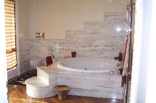 Vasca da bagno incassata in un rivestimento in marmo chiaro venato